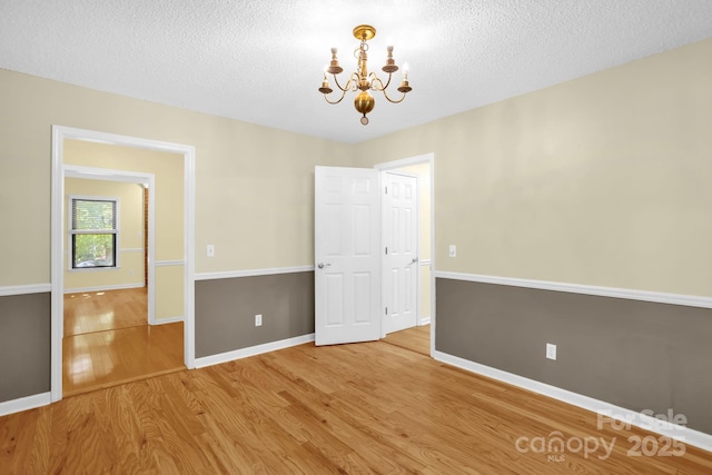 106 Birmingham Pl, Salisbury, NC 28146 - unfurnished room featuring a chandelier, wood finished floors, and a textured ceiling