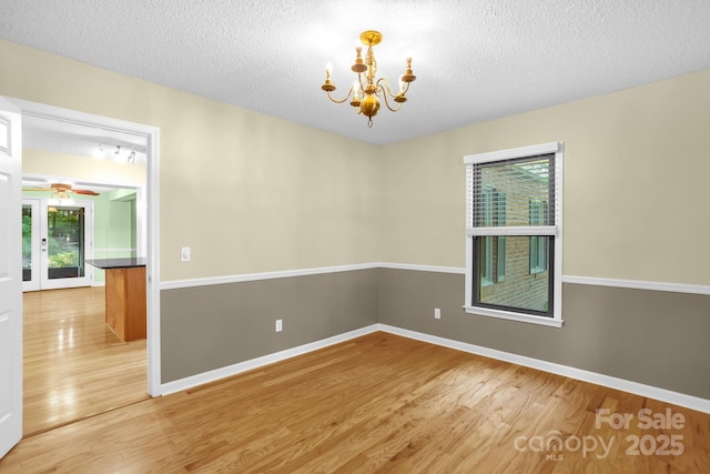 106 Birmingham Pl, Salisbury, NC 28146 - empty room featuring light wood-type flooring, a chandelier, plenty of natural light, ceiling fan, and a textured ceiling