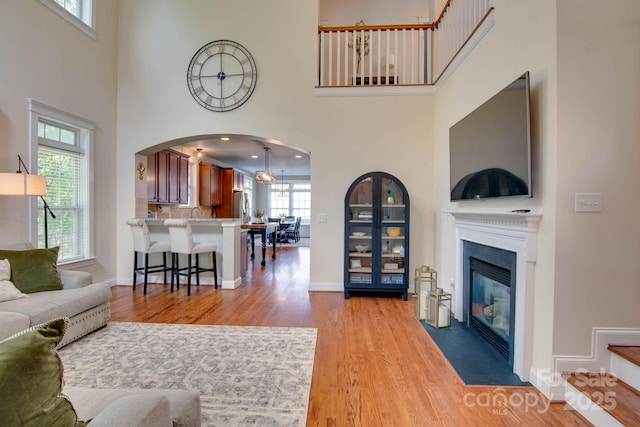 812 Cedar St, Mcadenville, NC 28101 - living room with light wood finished floors, a towering ceiling, a fireplace with flush hearth, and arched walkways