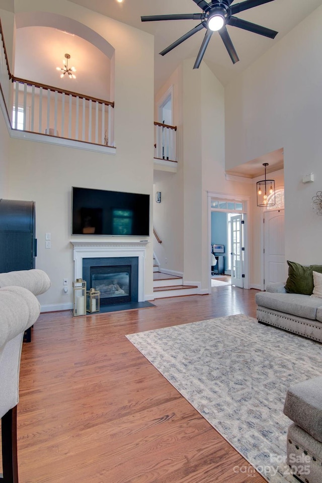 812 Cedar St, Mcadenville, NC 28101 - living room featuring high vaulted ceiling, a chandelier, wood finished floors, a fireplace with flush hearth, and a ceiling fan