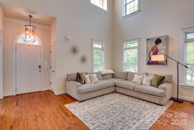 812 Cedar St, Mcadenville, NC 28101 - living area featuring a chandelier, plenty of natural light, light wood-style flooring, a high ceiling, and ornamental molding