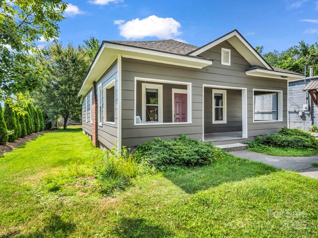 118 Railroad Ave, Brevard, NC 28712 - view of front of house featuring a front yard, covered porch, and roof with shingles