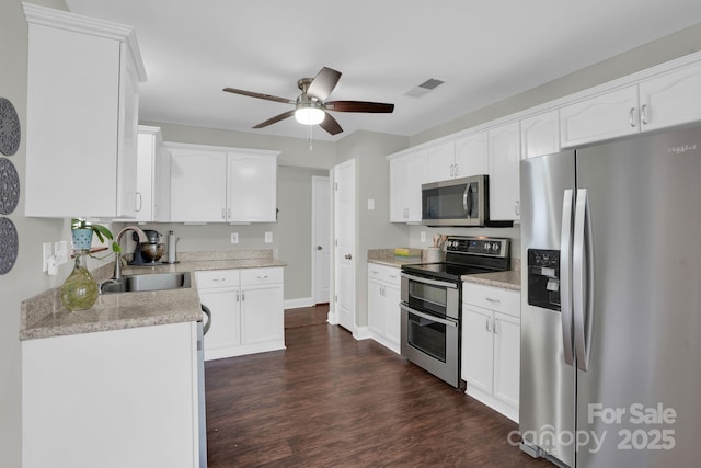 5901 Creft Cir, Indian Trail, NC 28079 - kitchen with appliances with stainless steel finishes, ceiling fan, dark wood-type flooring, and white cabinets
