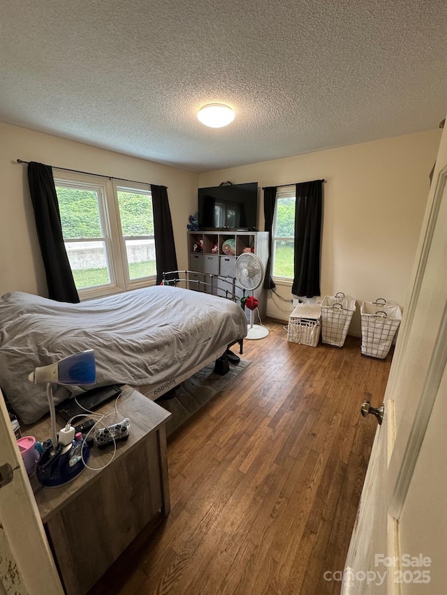 1045 Warren Pl NW, Lenoir, NC 28645 - bedroom featuring a textured ceiling, multiple windows, and hardwood / wood-style floors