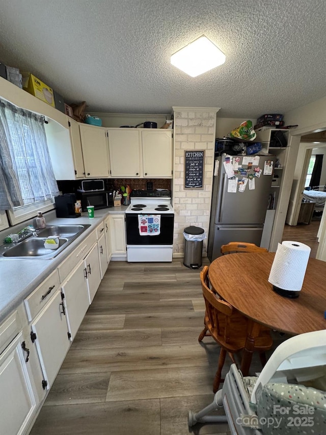 1045 Warren Pl NW, Lenoir, NC 28645 - kitchen featuring white range with electric cooktop, freestanding refrigerator, a textured ceiling, light countertops, and white cabinets