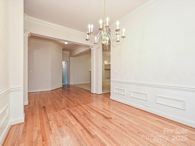 10638 Moss Mill Ln, Charlotte, NC 28277 - empty room featuring a chandelier, ornamental molding, light wood finished floors, wainscoting, and ornate columns