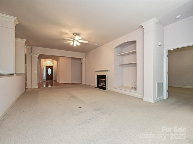 10638 Moss Mill Ln, Charlotte, NC 28277 - unfurnished living room with a ceiling fan, carpet flooring, a fireplace with flush hearth, built in features, and decorative columns