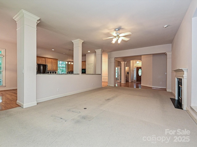 10638 Moss Mill Ln, Charlotte, NC 28277 - unfurnished living room with light colored carpet, ornate columns, a ceiling fan, a fireplace with flush hearth, and recessed lighting