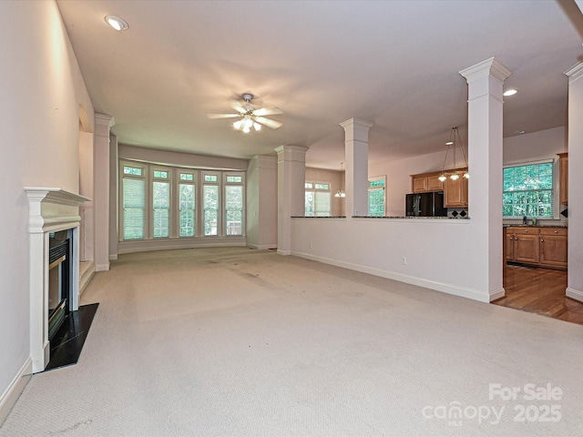 10638 Moss Mill Ln, Charlotte, NC 28277 - unfurnished living room with ornate columns, light colored carpet, ceiling fan, a fireplace with flush hearth, and recessed lighting