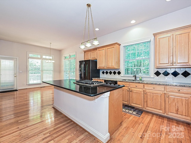 10638 Moss Mill Ln, Charlotte, NC 28277 - kitchen with black fridge with ice dispenser, light brown cabinetry, light wood-style floors, backsplash, and recessed lighting
