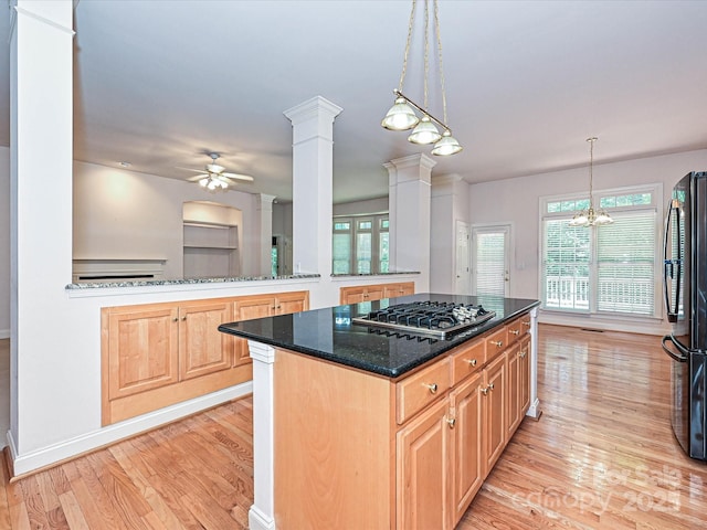 10638 Moss Mill Ln, Charlotte, NC 28277 - kitchen with stainless steel gas stovetop, freestanding refrigerator, light wood-type flooring, decorative columns, and a ceiling fan