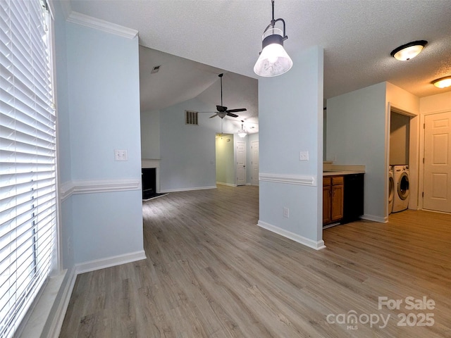 4002 Beaverbrook Dr, Indian Trail, NC 28079 - unfurnished living room with washer and dryer, a ceiling fan, light wood-type flooring, a textured ceiling, and a fireplace with raised hearth
