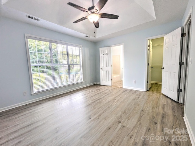 4002 Beaverbrook Dr, Indian Trail, NC 28079 - unfurnished bedroom featuring wood finished floors, a spacious closet, connected bathroom, and ceiling fan
