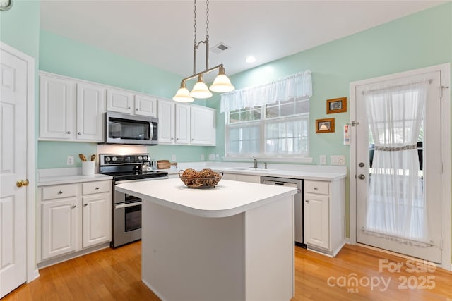 5630 Cambridge Bay Dr, Charlotte, NC 28269 - kitchen with appliances with stainless steel finishes, white cabinetry, light countertops, a center island, and recessed lighting