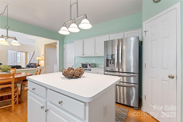 5630 Cambridge Bay Dr, Charlotte, NC 28269 - kitchen with stainless steel fridge with ice dispenser, a center island, light wood-style flooring, and white cabinetry