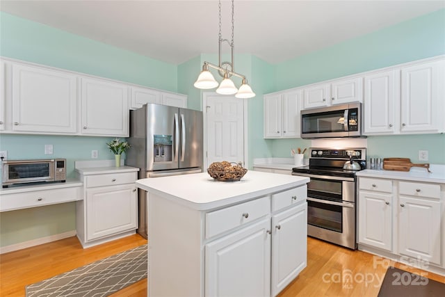 5630 Cambridge Bay Dr, Charlotte, NC 28269 - kitchen with appliances with stainless steel finishes, light wood finished floors, a kitchen island, and white cabinets