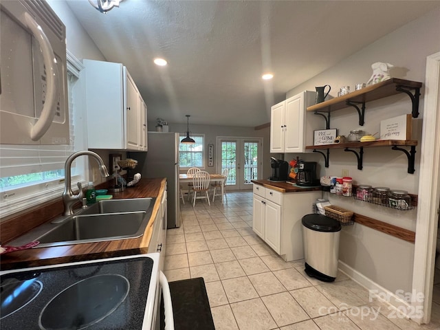 130 Sherwood Dr, Lake Lure, NC 28746 - kitchen with butcher block counters, french doors, white cabinetry, light tile patterned flooring, and open shelves