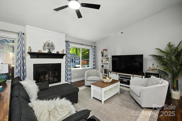 7627 Walnut Wood Dr, Charlotte, NC 28227 - living area with vaulted ceiling, a ceiling fan, a brick fireplace, and light wood-style flooring