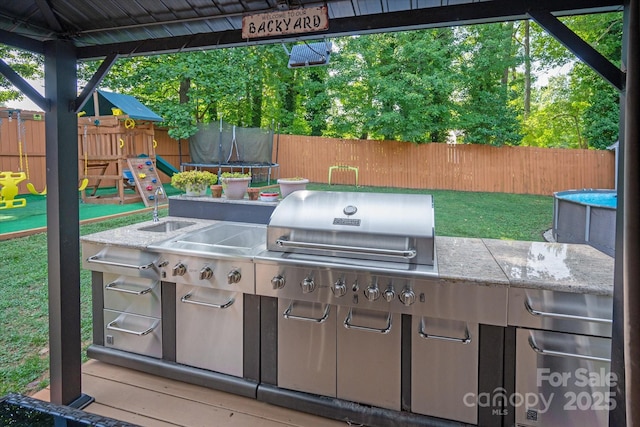 7627 Walnut Wood Dr, Charlotte, NC 28227 - view of patio / terrace featuring a trampoline, a playground, and exterior kitchen