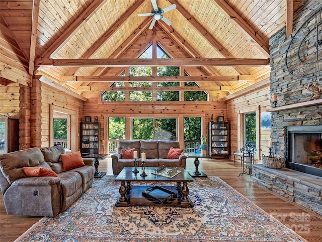 220 Circle Pines Dr, Rosman, NC 28772 - living area with high vaulted ceiling, a wooden ceiling with exposed beams, a ceiling fan, a stone fireplace, and wood walls
