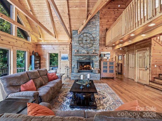 220 Circle Pines Dr, Rosman, NC 28772 - living area featuring high vaulted ceiling, wood walls, a wooden ceiling with exposed beams, wood finished floors, and a stone fireplace