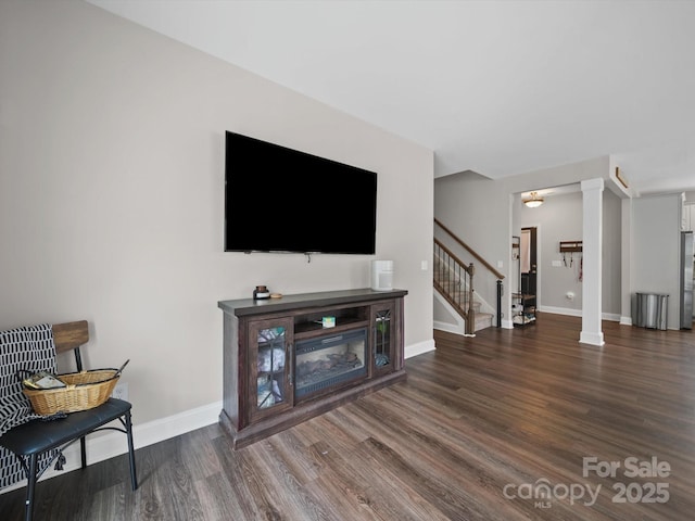 8810 Crape Myrtle Dr, Stanfield, NC 28163 - living room featuring wood finished floors, stairway, and decorative columns