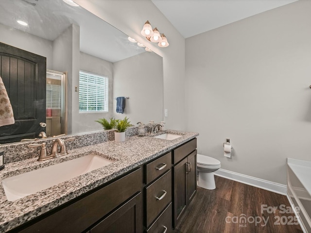 8810 Crape Myrtle Dr, Stanfield, NC 28163 - bathroom featuring wood finished floors, double vanity, a shower stall, and a bathtub