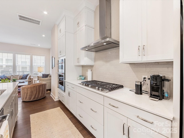 5018 Harrowsmith Ln, Charlotte, NC 28204 - kitchen with wall chimney range hood, stainless steel appliances, open floor plan, white cabinetry, and dark wood-style floors