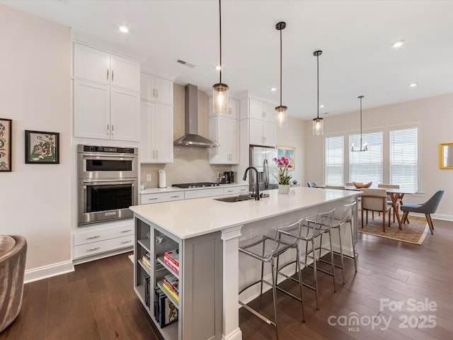 5018 Harrowsmith Ln, Charlotte, NC 28204 - kitchen featuring wall chimney range hood, appliances with stainless steel finishes, open shelves, dark wood finished floors, and recessed lighting