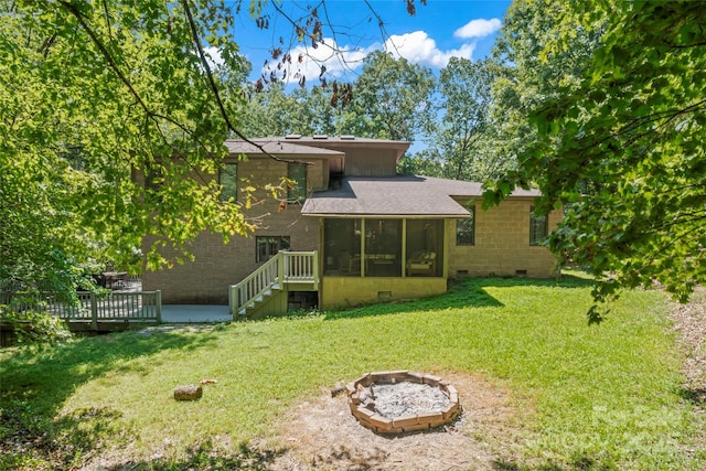 6724 Riverfront Dr, Charlotte, NC 28216 - rear view of property featuring a sunroom, crawl space, a fire pit, a lawn, and a deck