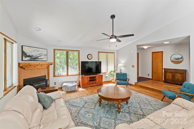 6724 Riverfront Dr, Charlotte, NC 28216 - living room featuring lofted ceiling, ceiling fan, wood finished floors, and a tile fireplace