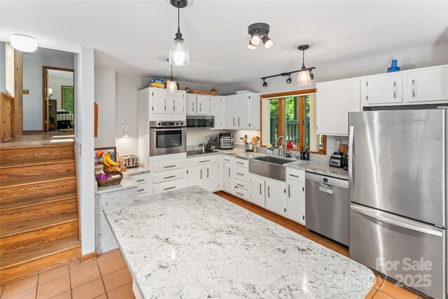 6724 Riverfront Dr, Charlotte, NC 28216 - kitchen featuring appliances with stainless steel finishes, white cabinets, light tile patterned floors, light stone countertops, and hanging light fixtures