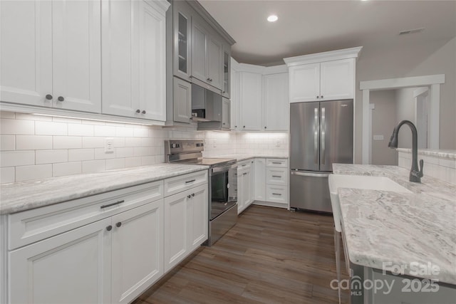5005 Oconee Dr, Stanley, NC 28164 - kitchen with appliances with stainless steel finishes, decorative backsplash, dark wood-style floors, light stone counters, and recessed lighting