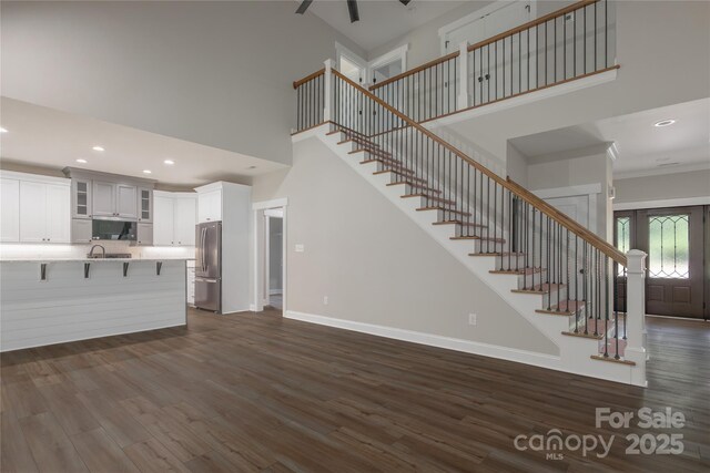 5005 Oconee Dr, Stanley, NC 28164 - unfurnished living room with a high ceiling, dark wood-type flooring, stairs, and recessed lighting