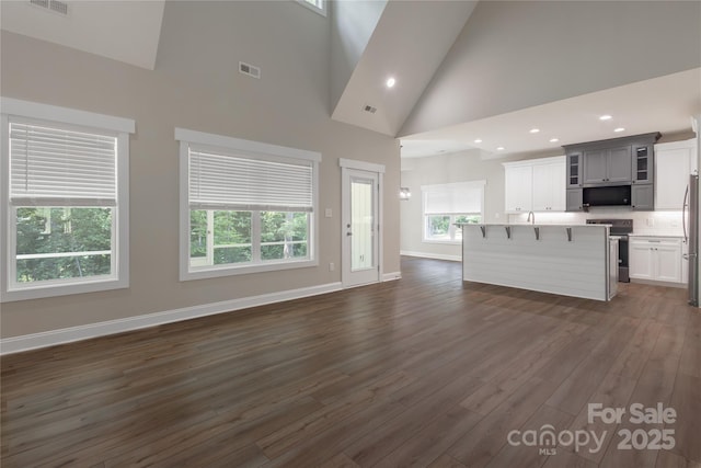 5005 Oconee Dr, Stanley, NC 28164 - unfurnished living room featuring high vaulted ceiling, dark wood finished floors, and recessed lighting