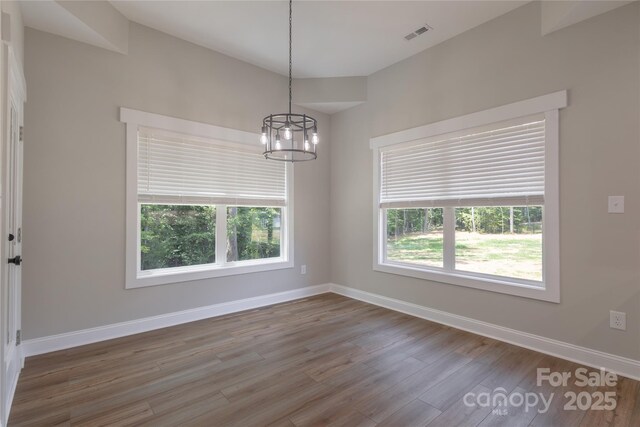 5005 Oconee Dr, Stanley, NC 28164 - empty room featuring wood finished floors, a chandelier, and plenty of natural light