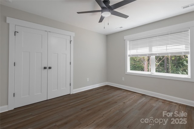 5005 Oconee Dr, Stanley, NC 28164 - unfurnished bedroom with dark wood-style flooring, a closet, and ceiling fan