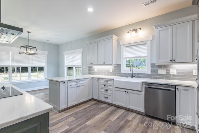5009 Oconee Dr, Stanley, NC 28164 - kitchen with stainless steel dishwasher, a peninsula, exhaust hood, light wood-style flooring, and decorative backsplash