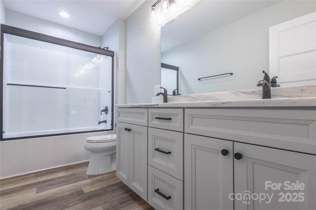 5009 Oconee Dr, Stanley, NC 28164 - full bathroom featuring wood finished floors, double vanity, enclosed tub / shower combo, and recessed lighting