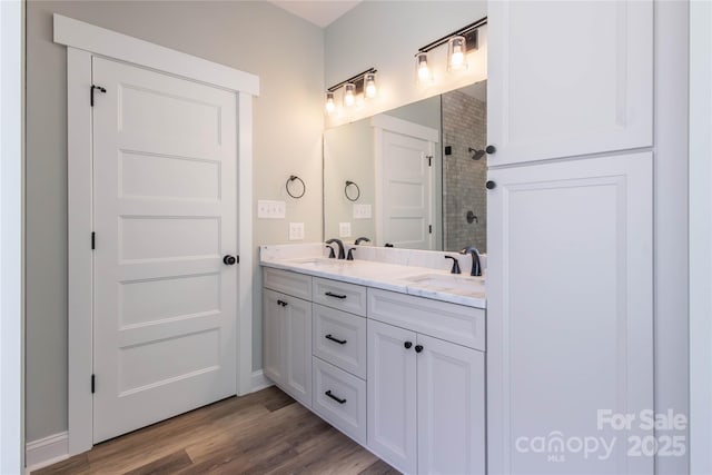 5009 Oconee Dr, Stanley, NC 28164 - bathroom with double vanity, a tile shower, and wood finished floors