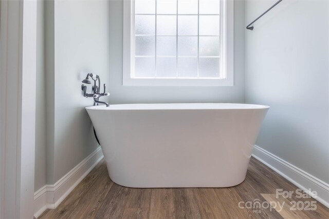 5009 Oconee Dr, Stanley, NC 28164 - bathroom with a freestanding tub and wood finished floors