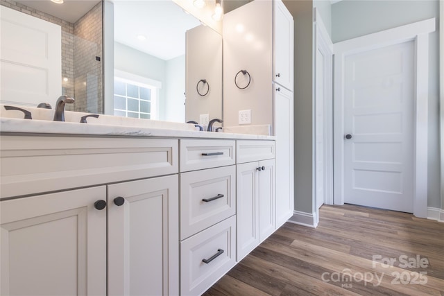 5009 Oconee Dr, Stanley, NC 28164 - bathroom with double vanity, wood finished floors, and a tile shower