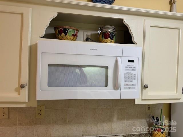 1678 Robins Nest Ct Unit B, Gastonia, NC 28054 - kitchen view of white microwave, tasteful backsplash, and white cabinets