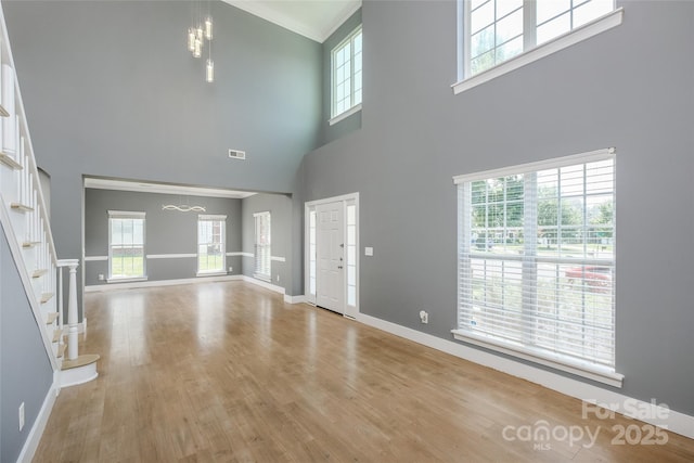 2002 Ledare Ln Unit 70, Indian Trail, NC 28079 - unfurnished living room with wood finished floors, stairs, a towering ceiling, and crown molding