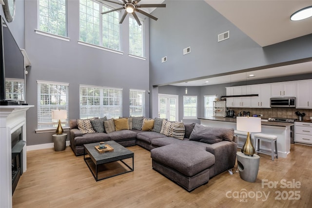 2002 Ledare Ln Unit 70, Indian Trail, NC 28079 - living area featuring a towering ceiling, ceiling fan, light wood-type flooring, and a fireplace