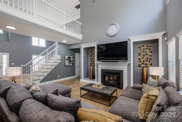 2002 Ledare Ln Unit 70, Indian Trail, NC 28079 - living area with a towering ceiling, stairway, a warm lit fireplace, and wood finished floors