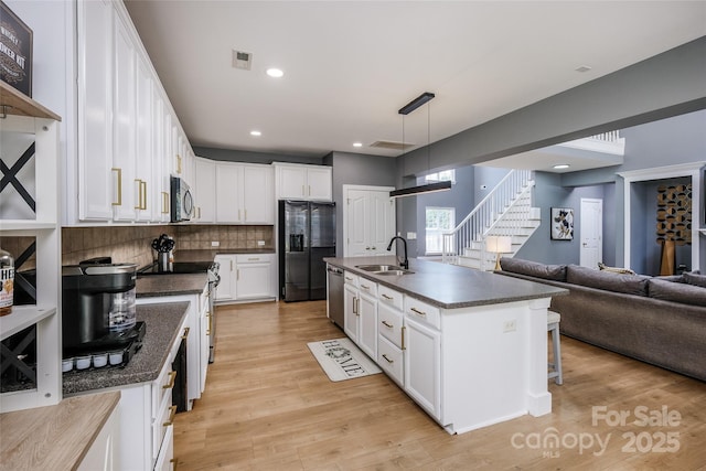 2002 Ledare Ln Unit 70, Indian Trail, NC 28079 - kitchen featuring dark countertops, black fridge with ice dispenser, white cabinetry, backsplash, and recessed lighting