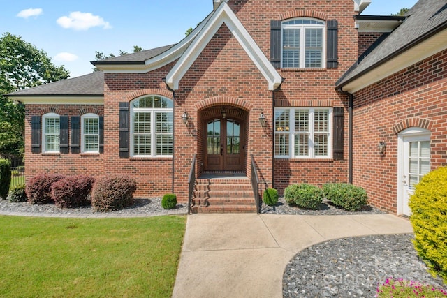120 Cheyenne Ln, Statesville, NC 28677 - view of exterior entry featuring french doors, brick siding, a shingled roof, and a lawn