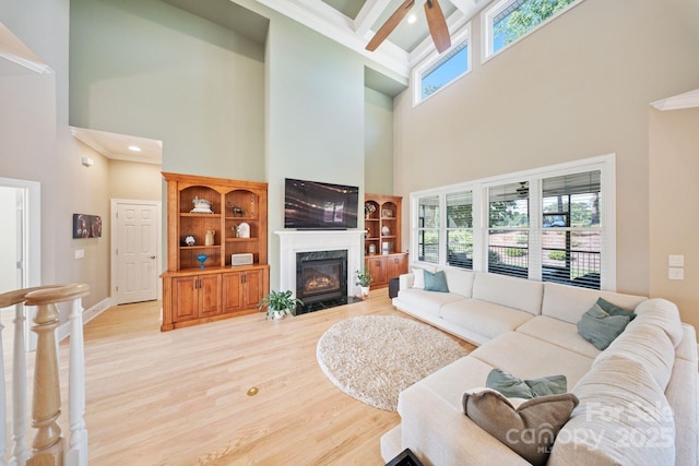 120 Cheyenne Ln, Statesville, NC 28677 - living area with a high ceiling, a fireplace, light wood-style flooring, a ceiling fan, and crown molding