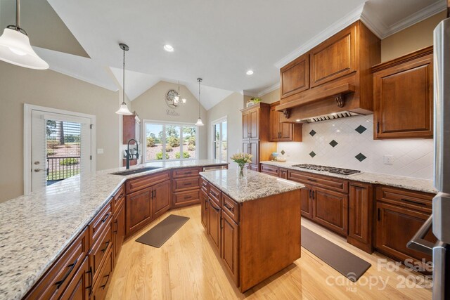 120 Cheyenne Ln, Statesville, NC 28677 - kitchen with stainless steel gas stovetop, light wood finished floors, vaulted ceiling, exhaust hood, and a center island